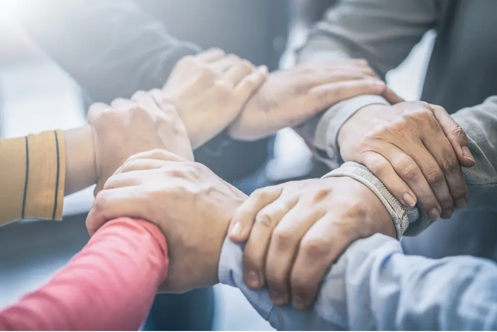 Hands joined together in support during a counseling session